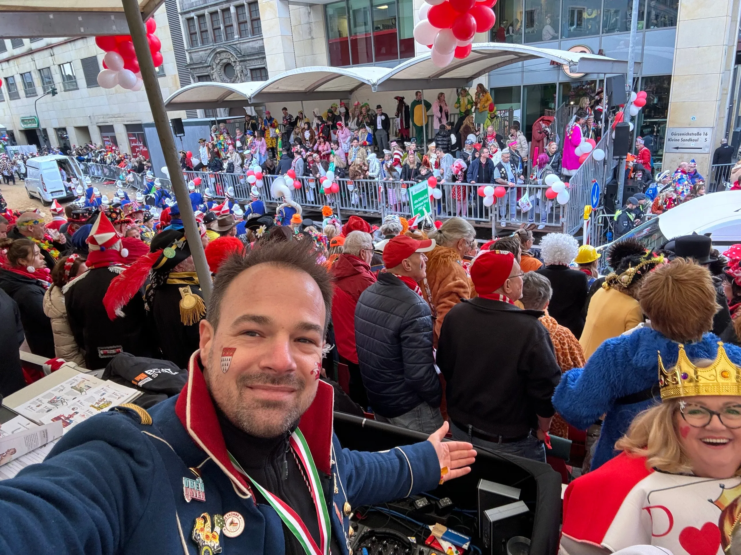 Leere rot-weiße Tribünensitze vor dem Rosenmontagszug in der Abenddämmerung, Wegweiser Richtung Rathaus und Dom