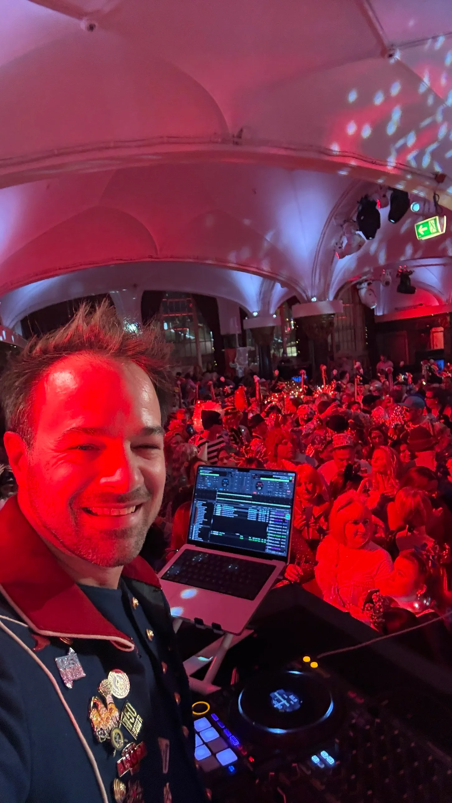 René Braun am Pult mit Laptop, dahinter der volle Saal im roten Licht
